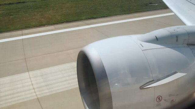 View from the window of a plane moving at the airport. Preparing for takeoff. View of the turbine of the aircraft and the off on runway. Takeoff moment airplane in flight, view from plane window
