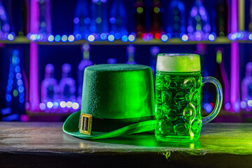 Mugs of green beer, ale on the bar counter. Holiday of Ireland on St. Patrick's Day in irish pub, bar. Festive Leprikon's green hat. National tradition of carnival celebrating March 17