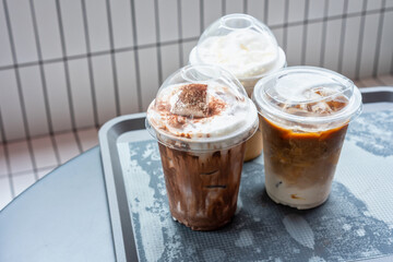 various drinks in plastic cups on the table in the mall. Selective focus