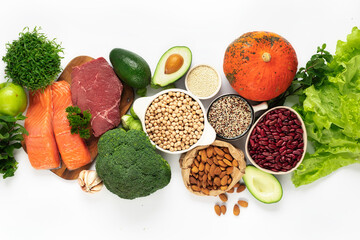 Raw healthy food, clean eating concept. Green vegetables, legumes with beef meat and salmon fish on white background top view. Balanced diet