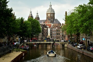 Fototapeta premium Boat on canal, beautiful building in background in Amsterdam 