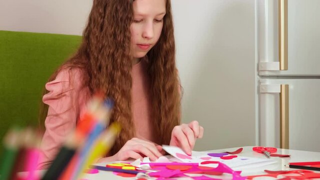 Kids, children, doing Valentine's Day arts and crafts with hearts, pencils, paper. Gift, surprize for mom. Children makes Handmade decorations for holiday. Prepare for Valentine Day. Painting, DIY