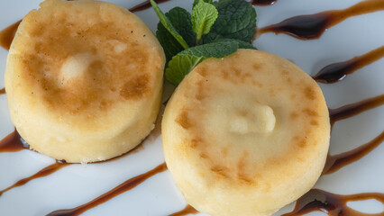 Tasty cheese pancakes with caramel sauce, powdered sugar and mint. Cottage cheese pancakes for Breakfast or lunch.