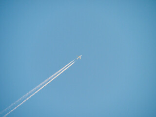 Aeroplane / Airplane Jet in flight Clear Blue Sky with White Cloud Trail 