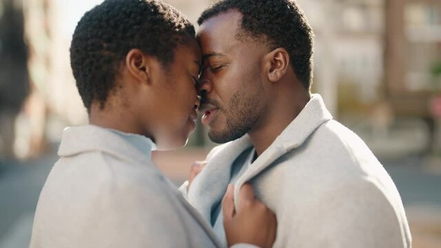 African american couple kissing and hugging each other at street