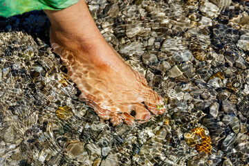 Female feet on the seashore.