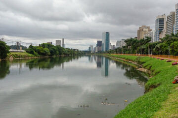 polluted Pinheiros river in Sao Paulo, Brazil. bike lane and buildings cityscape