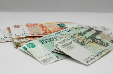 Russian banknotes in denominations of 50, 1000 and 5000 rubles. White neutral background.