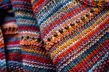 Fragment of knitted woolen cloth, close-up. Self-knitted clothing.