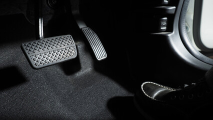 Accelerator and breaking pedal in a car. Close up the foot pressing foot pedal of a car to drive...