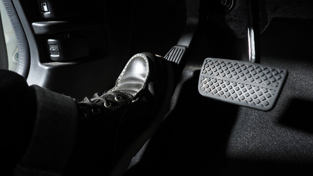 Accelerator and breaking pedal in a car. Close up the foot pressing foot pedal of a car to drive ahead. Driver driving the car by pushing accelerator pedals of the car. inside vehicle.