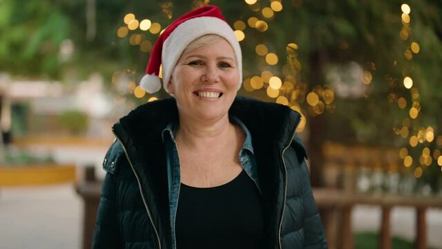 Mother and son wearing christmas hat surprise with gift at park