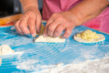 mom makes pies with potatoes out of dough. High quality photo