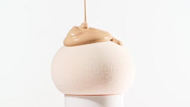 Make-up liquid beige foundation pouring on sponge, closeup. Cosmetic Dripping bb Cream on makeup brush on white background. Macro Shot. Beautiful Makeup concept. High quality 4k footage
