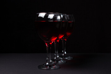 Three glasses of red wine on a black background. Alcoholic drink.	