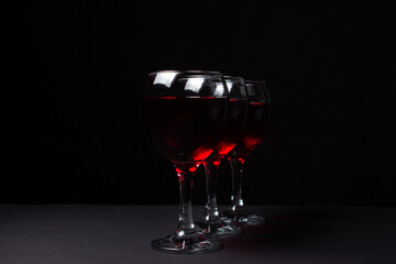 Three glasses of red wine on a black background. Alcoholic drink.