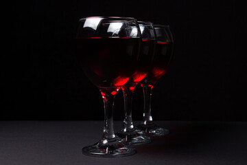 Three glasses of red wine on a black background. Alcoholic drink.