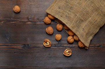 harvest of walnuts spills out of the bag on a wooden table, place for an object