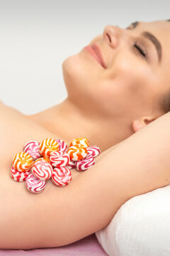 Colored round candies under the female armpit, close up, depilation armpit concept