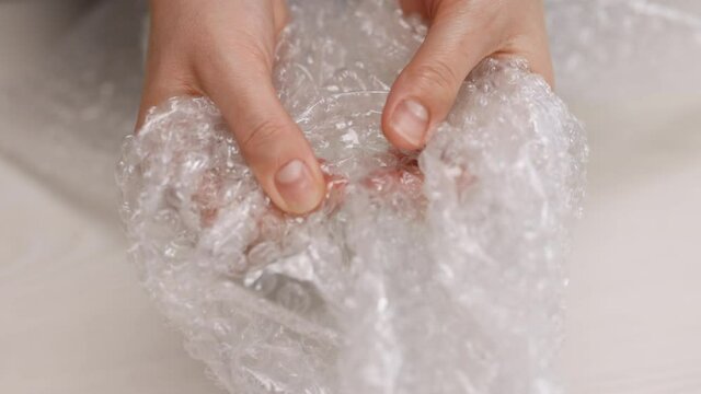 Woman's hands pressing hard on a bubble paper. Girl pressing the bubble wrapping. Stress concept