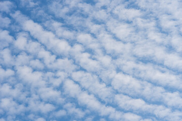 White cirrocumulus clouds against a blue sky, background..
