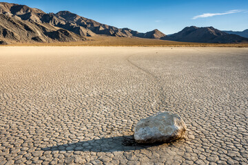 Long Shadow Falls Across A Sailing Stone With Its Path Fading Across The Racetrack