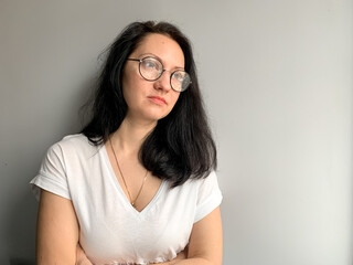 Young woman is drinking coffee by the window at home. Covid restrictions, self isolation, burned...