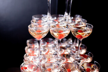 Champagne pyramid with cherries in dark colors