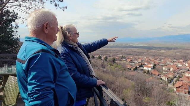 Senior Romantic Couple On The Top Of A Hill Enjoying The View Of The City After A Weekend Hike, Slow Motion