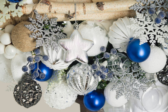 Christmas decoration made of baubles, berries, snowflakes, jute, stars and birch branches in white blue and silver tones. New Years background.