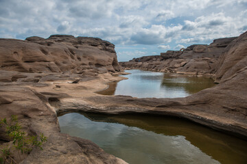Fototapeta na wymiar Colorful rocks, puddles and strange shaped rocks in the Mekong River