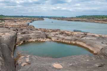 Fototapeta premium Colorful rocks, puddles and strange shaped rocks in the Mekong River