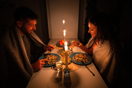 Couple having dinner at home during power outage. Blackout, no electricity