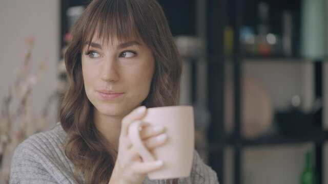 Casual young woman with skin depigmentation enjoying morning coffee at home