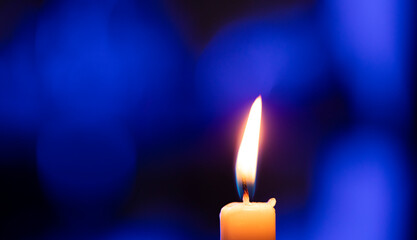 burning candle on black background. Blue background. Light. Candle. 
