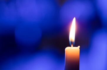 burning candle on black background