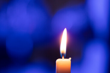 burning candle on dark background