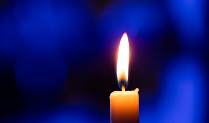 burning candle on black background