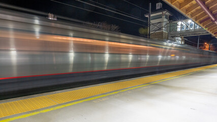 High-speed train going through a station at night. Motion blur transportation concept.