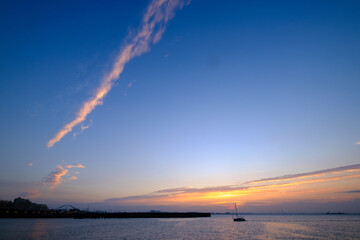 早朝、兵庫県芦屋市芦屋浜より大阪湾、西宮浜方面を臨む。空がオレンジ色に染まり大阪南港のビル群がシルエットで浮かぶ