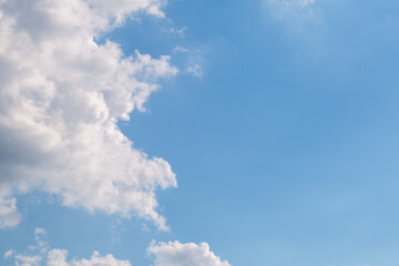 Blue sky with fluffy clouds on a sunny day