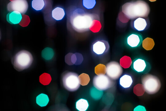 black abstract background with multicolored lights with bokeh in blur