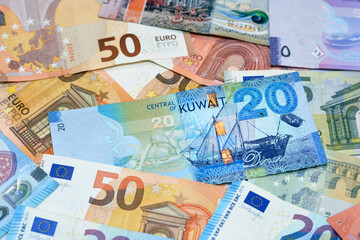 Kuwait dinars money banknote bills with European euro banknotes background, selective focus of pile of Kuwaiti dinars and European euros banknotes currency exchange rates - obrazy, fototapety, plakaty