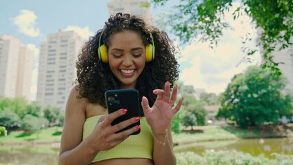 Latin woman using smartphone in the park. Brazilian girl. Cinematic 4k.