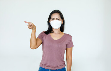 Portrait Asian woman wearing a face mask poses, pointing adverti