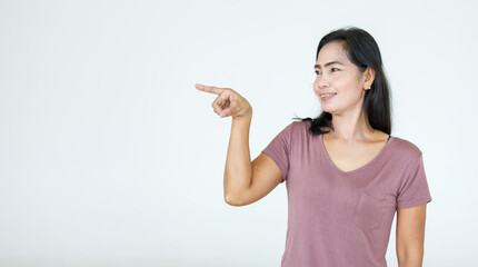 Portrait Asian beautiful woman wearing casual shirt standing poses, pointing advertisement on white background, blank copy space with an isolated smiling look at the camera.