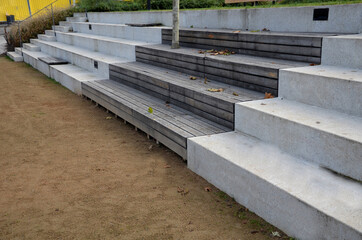 concrete staircase serves as a theater bench overlooking river. cobblestone cobblestones cubes on promenade with wooden benches. you can also sit on long wide stairs lined with tropical wood. drain 