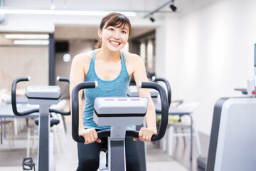 Obraz premium ジムでマシーントレーニングをする若い女性