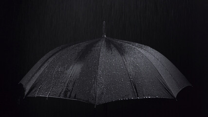 Photo of the black umbrella and rainy drops on black background - obrazy, fototapety, plakaty