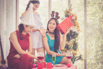 Group of cheerful girls friend having christmas party and drinks enjoy together at her house.